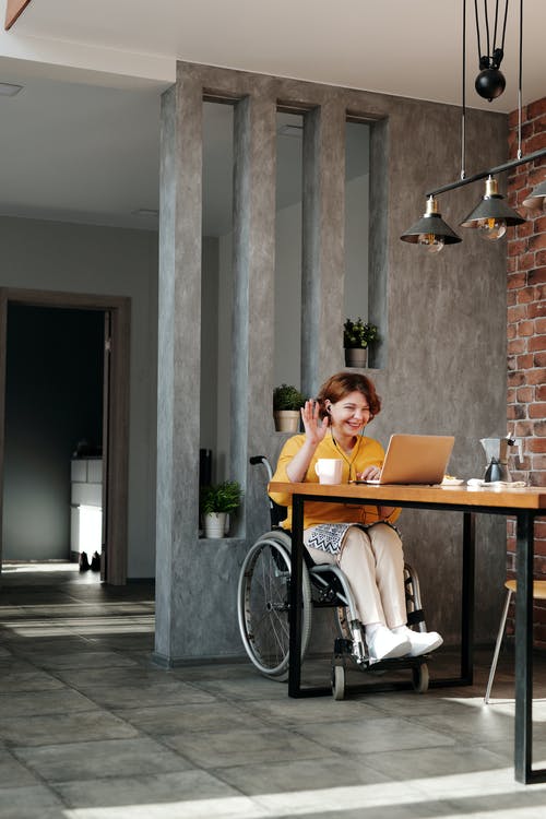 Woman in orange top sitting on black wheelchair